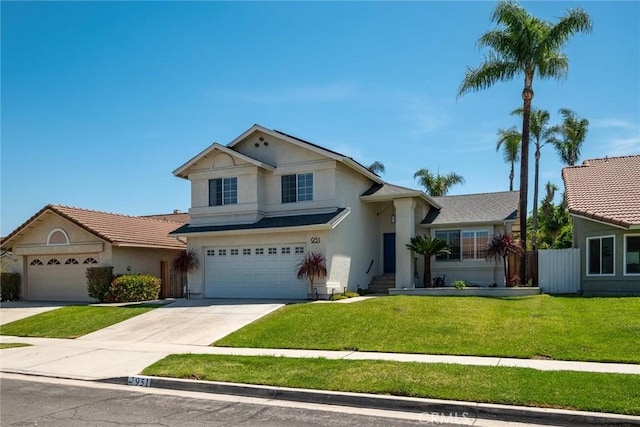 traditional-style house with a front yard, a garage, concrete driveway, stucco siding, and fence