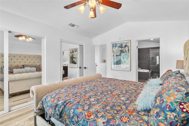 bedroom with wood finished floors, vaulted ceiling, ceiling fan, ensuite bathroom, and visible vents
