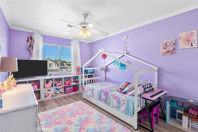 bedroom with ornamental molding, visible vents, ceiling fan, and wood finished floors