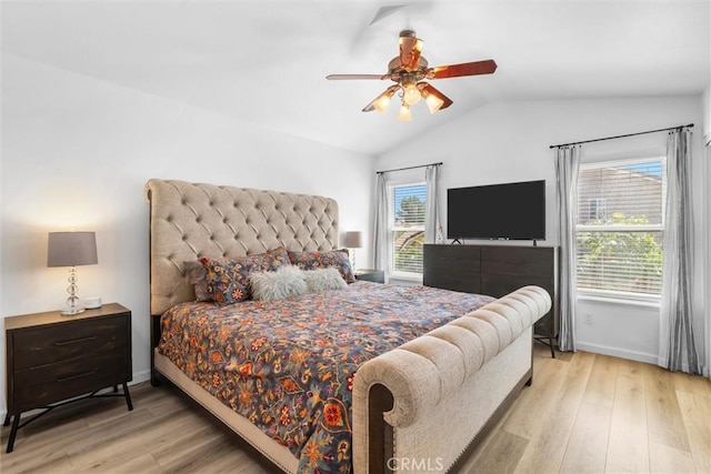 bedroom with a ceiling fan, vaulted ceiling, wood finished floors, and baseboards