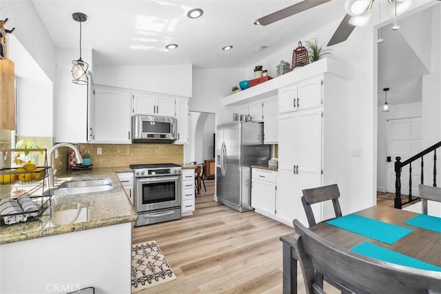 kitchen with tasteful backsplash, appliances with stainless steel finishes, ceiling fan, a sink, and white cabinetry