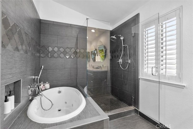 full bath with a stall shower and a whirlpool tub