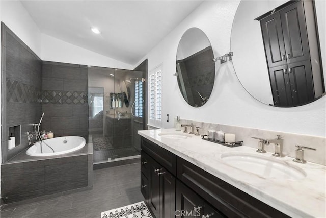 full bathroom featuring a bath, a sink, a shower stall, and vaulted ceiling