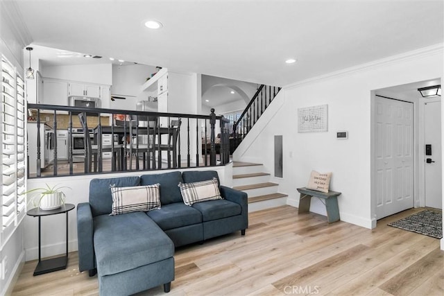 living area with crown molding, light wood-style flooring, and recessed lighting