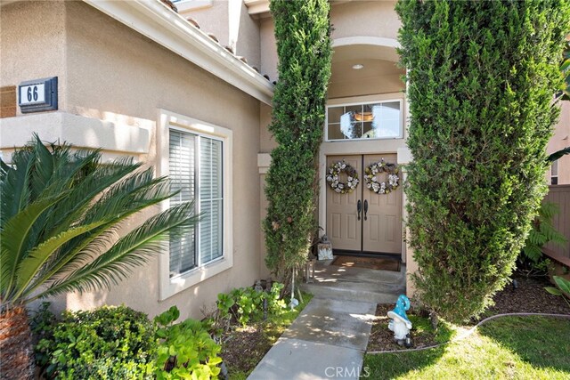 entrance to property featuring stucco siding