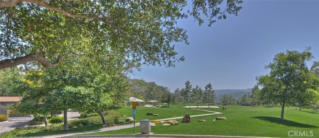 surrounding community with a yard and a mountain view
