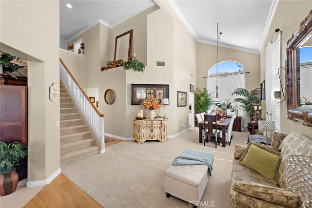 living room featuring stairway, baseboards, a towering ceiling, and visible vents