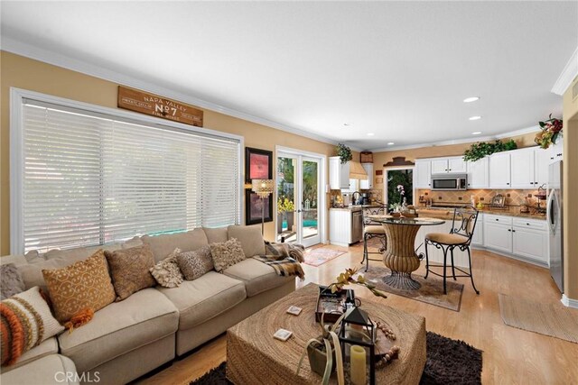 living room featuring light wood-style floors, recessed lighting, and ornamental molding