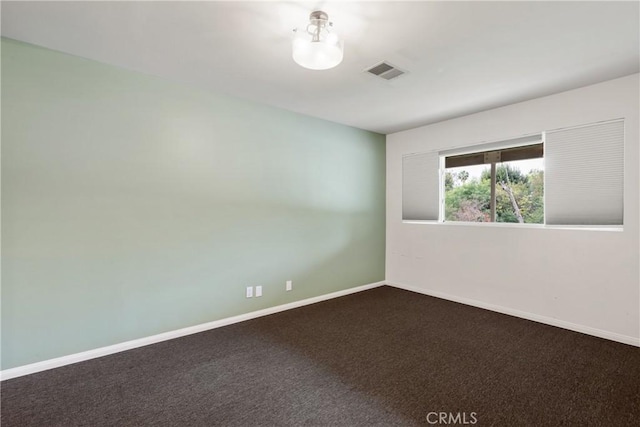unfurnished room with baseboards, visible vents, and carpet