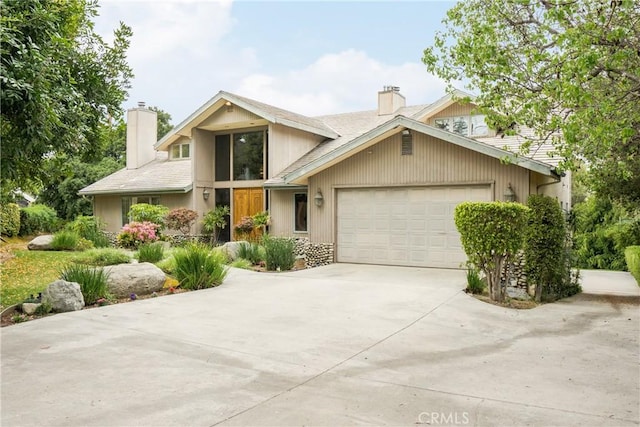 mid-century modern home featuring driveway, a chimney, and a garage