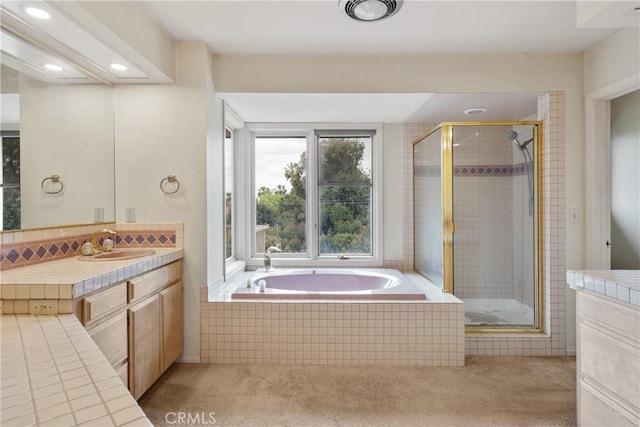 bathroom with recessed lighting, a bath, vanity, and a stall shower