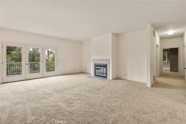 unfurnished living room featuring visible vents, carpet flooring, and a fireplace
