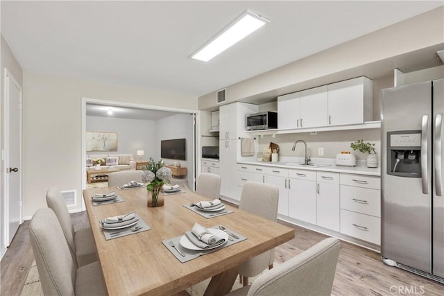 dining space featuring light wood-type flooring and visible vents
