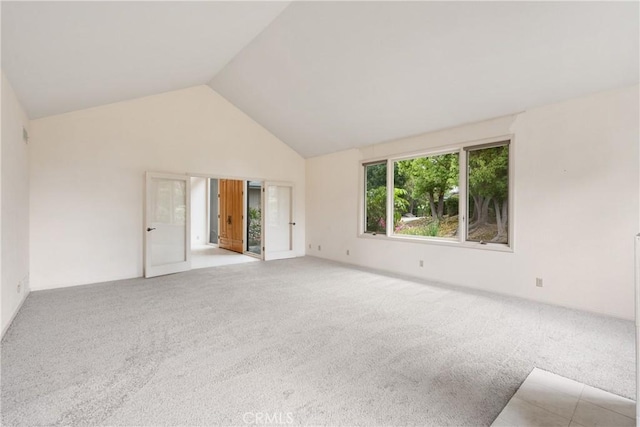 spare room with carpet floors and high vaulted ceiling