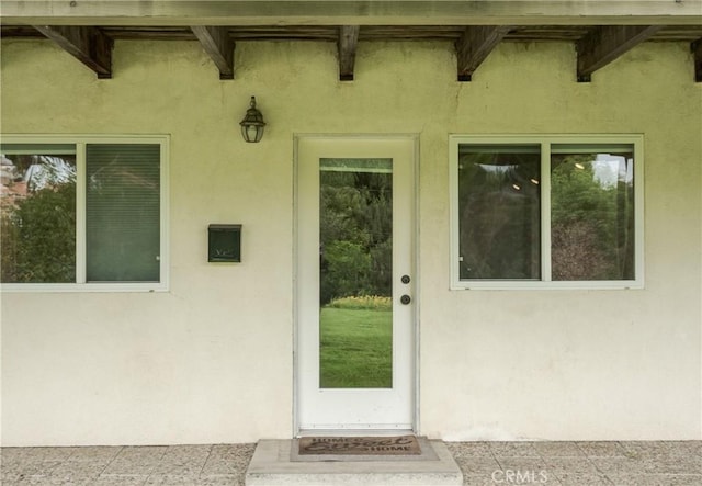view of exterior entry featuring stucco siding