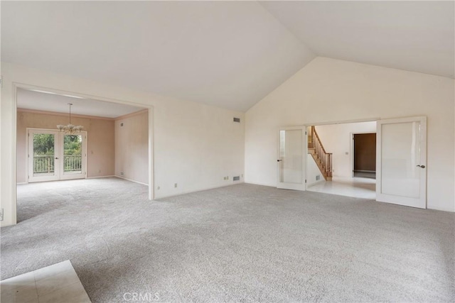 unfurnished living room featuring vaulted ceiling, visible vents, carpet, a notable chandelier, and stairs
