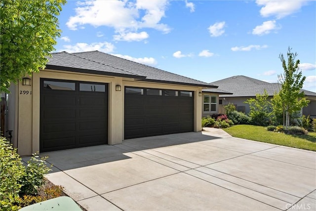 view of front facade featuring an attached garage, stucco siding, and concrete driveway