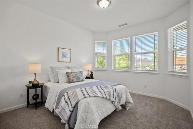 bedroom featuring baseboards, visible vents, multiple windows, and carpet