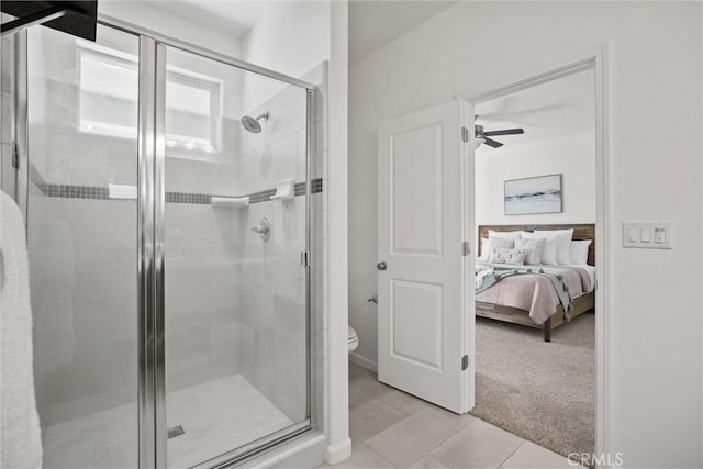 ensuite bathroom featuring toilet, ceiling fan, connected bathroom, tile patterned floors, and a shower stall