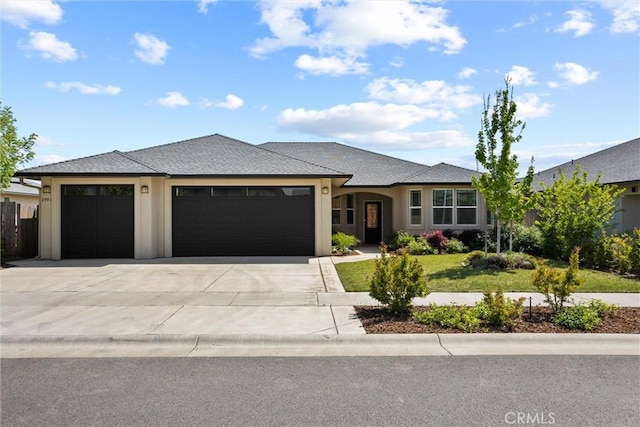 view of front of home with an attached garage, roof with shingles, a front yard, and concrete driveway