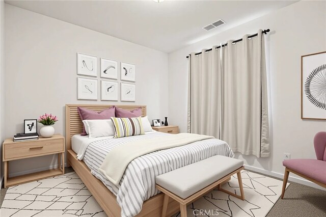 bedroom with visible vents, baseboards, and light wood finished floors