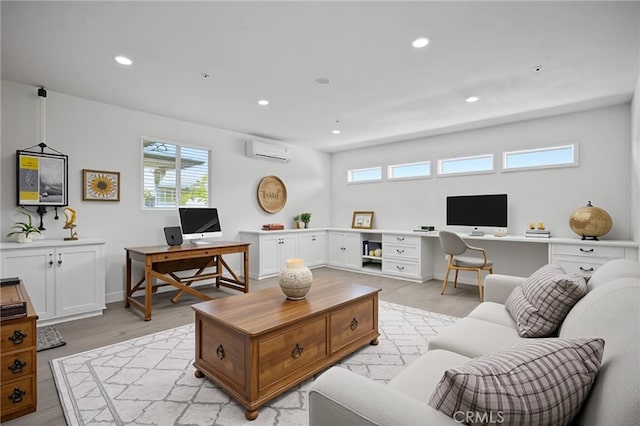 living area featuring an AC wall unit, baseboards, recessed lighting, and light wood-style flooring