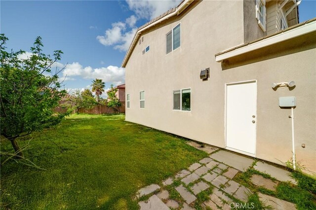 29444 Siderite Cir, Menifee, CA 92584 - view of side of home with a lawn, fence, and stucco siding