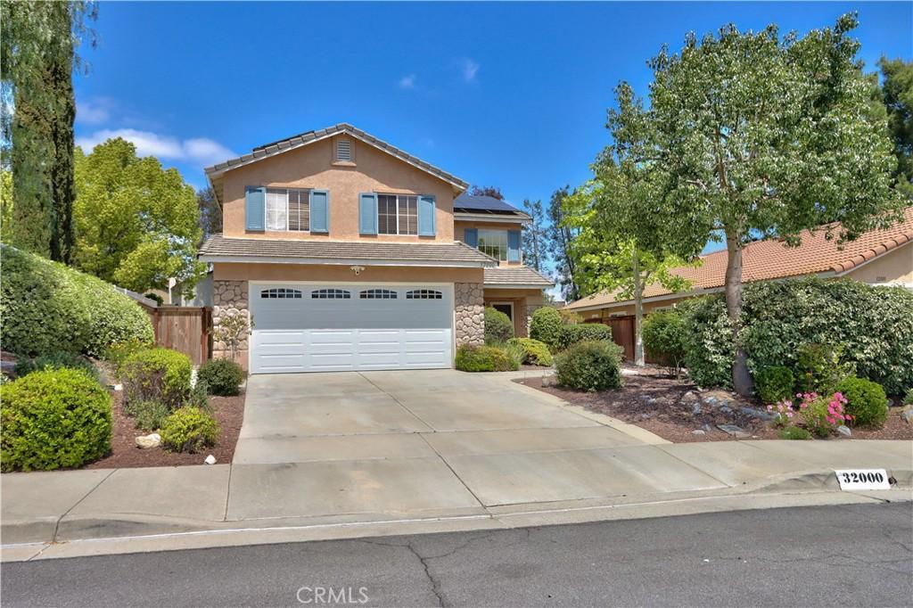 32000 Corte Sagunto, Temecula, CA 92592 - traditional-style house with driveway, solar panels, an attached garage, stone siding, and stucco siding
