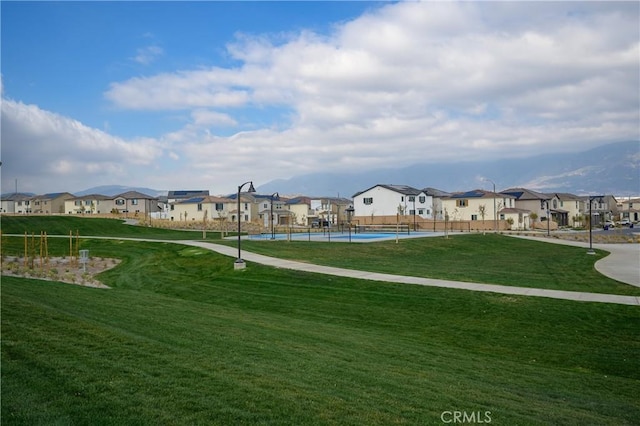 view of community with a yard, fence, and a residential view