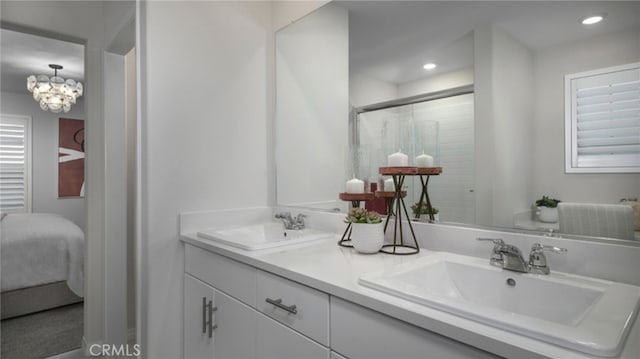 ensuite bathroom featuring an inviting chandelier, ensuite bathroom, a sink, and double vanity