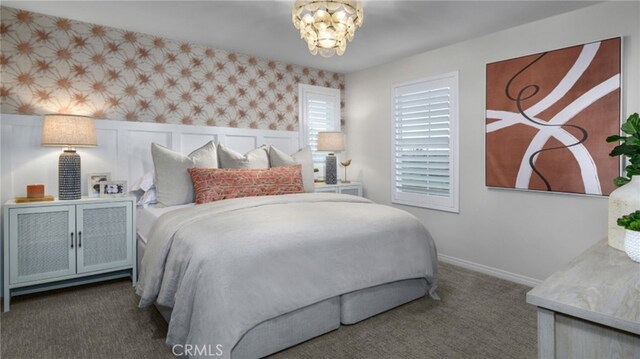 carpeted bedroom featuring wallpapered walls, baseboards, and an inviting chandelier