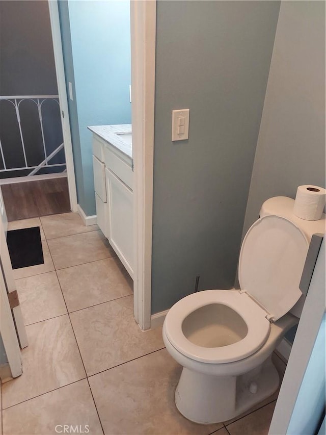 bathroom featuring tile patterned floors, baseboards, vanity, and toilet