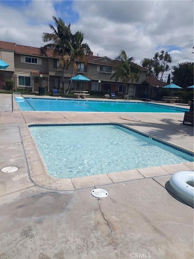pool with fence and a patio