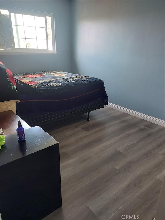 bedroom with baseboards and wood finished floors