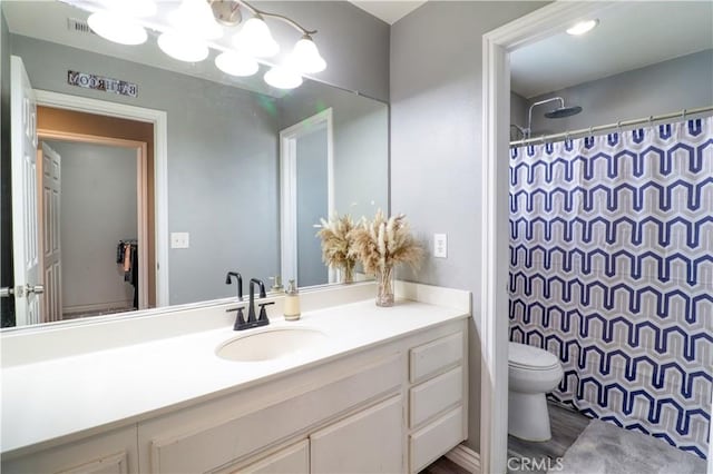 bathroom featuring toilet, visible vents, curtained shower, and vanity