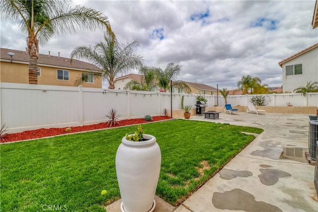 view of yard featuring a fenced backyard, a patio, and a fire pit