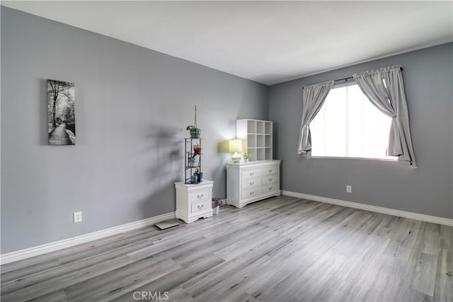 unfurnished bedroom with baseboards and wood finished floors