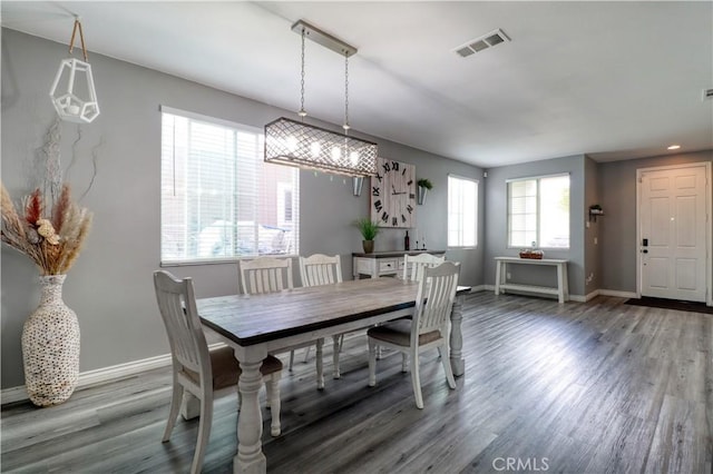 dining room with baseboards, visible vents, and wood finished floors