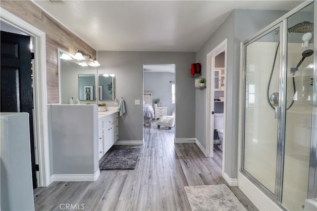 full bath featuring vanity, wood finished floors, toilet, a shower stall, and ensuite bath