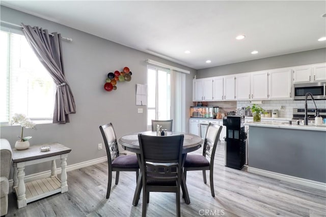 dining room featuring baseboards, recessed lighting, and light wood-style flooring