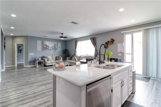 kitchen with stainless steel dishwasher, visible vents, white cabinetry, a sink, and light wood finished floors