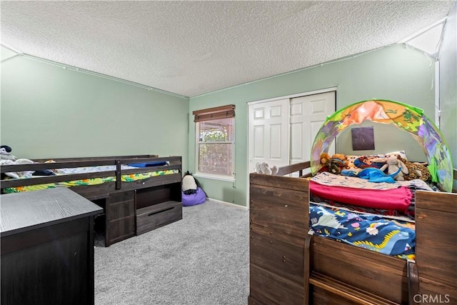 carpeted bedroom featuring baseboards, a textured ceiling, and a closet