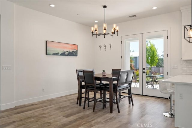 dining room featuring a chandelier, visible vents, light wood-style floors, and recessed lighting