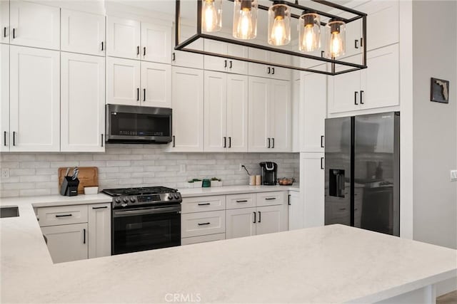 kitchen with pendant lighting, stainless steel appliances, decorative backsplash, and white cabinets