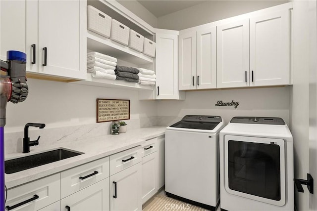 laundry room featuring a sink, washer and dryer, and cabinet space