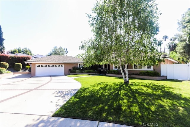 2812 Sunnywood Dr, Fullerton, CA 92835 - view of front of house with fence, a front lawn, stucco siding, driveway, and a garage