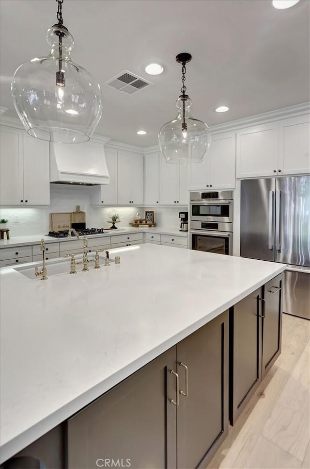 1711 Colina Terrestre, San Clemente, CA 92673 - kitchen with appliances with stainless steel finishes, custom range hood, white cabinets, light countertops, and recessed lighting