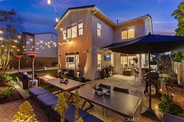 1711 Colina Terrestre, San Clemente, CA 92673 - back of property at dusk featuring an outdoor living space with a fire pit, stucco siding, a patio area, and outdoor dining space