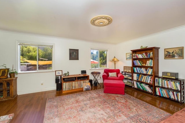 sitting room featuring baseboards, crown molding, and hardwood / wood-style floors