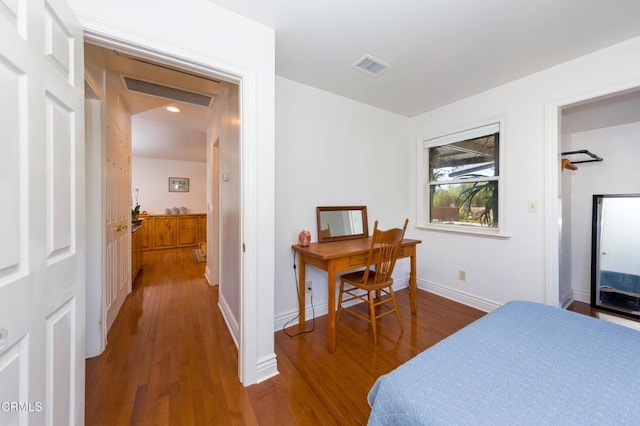 bedroom featuring wood finished floors, visible vents, and baseboards